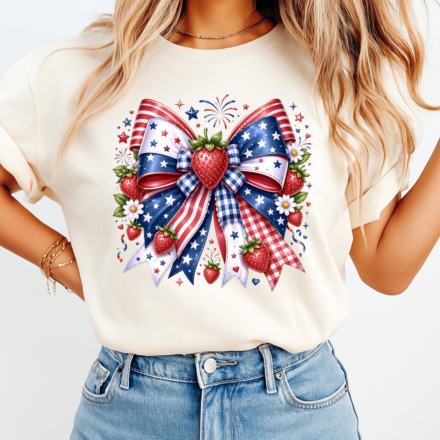 Person wearing a white t-shirt with a patriotic design featuring a bow, strawberries, and fireworks.