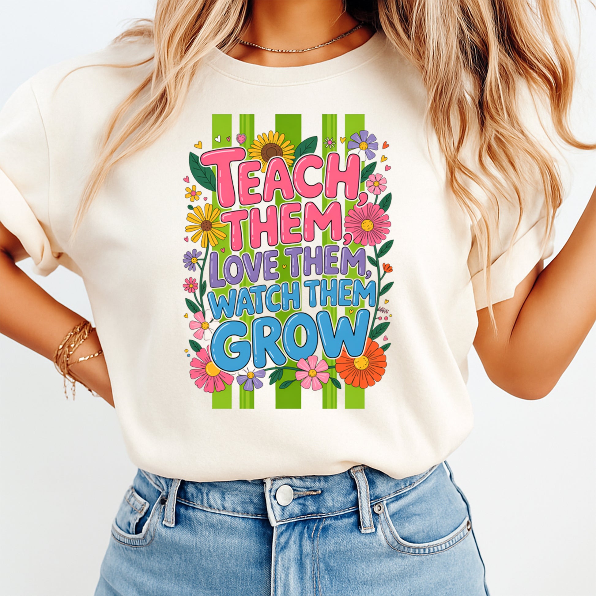 Person wearing a white t-shirt with colorful text and floral design on a plain background