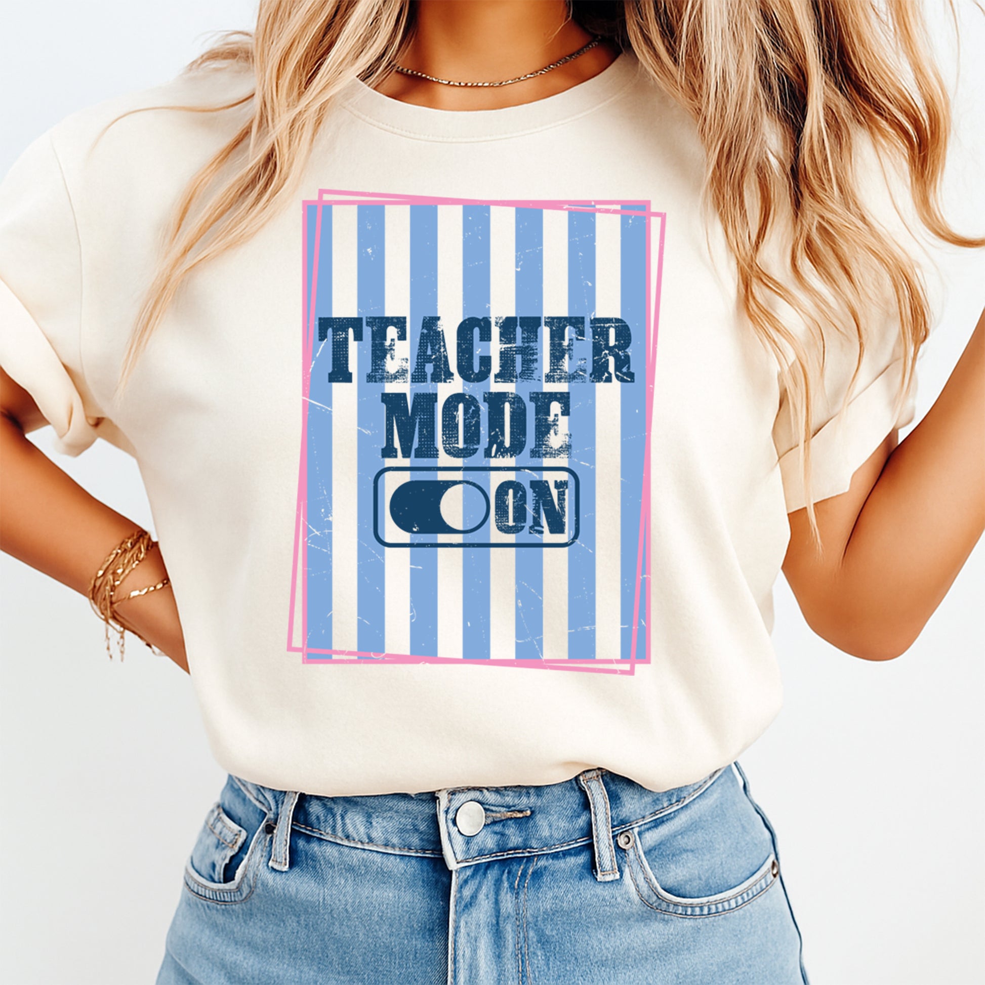 Person wearing a t-shirt with 'Teacher Mode ON' design on a plain background