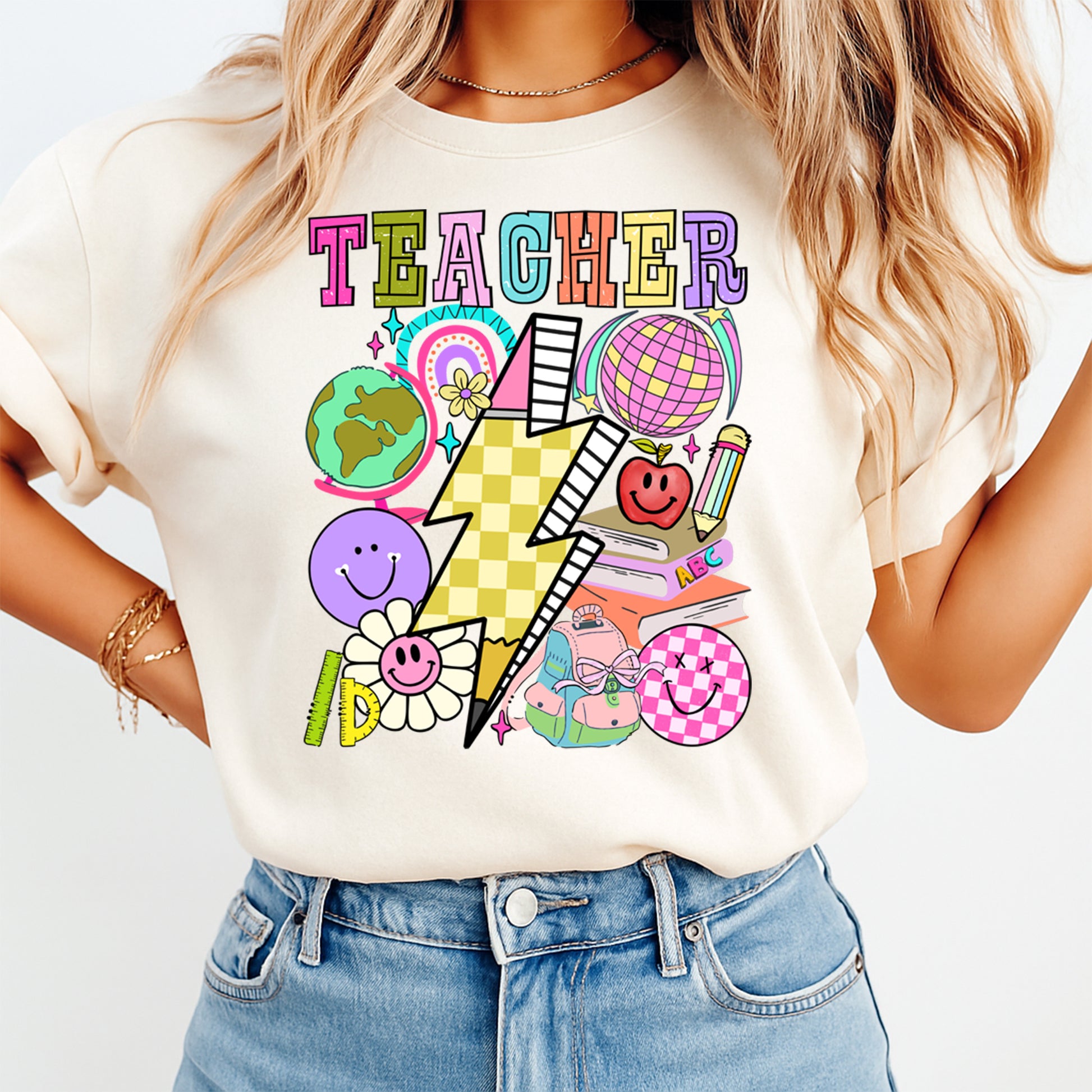 Person wearing a white t-shirt with colorful graphics and the word 'TEACHER' on a plain background