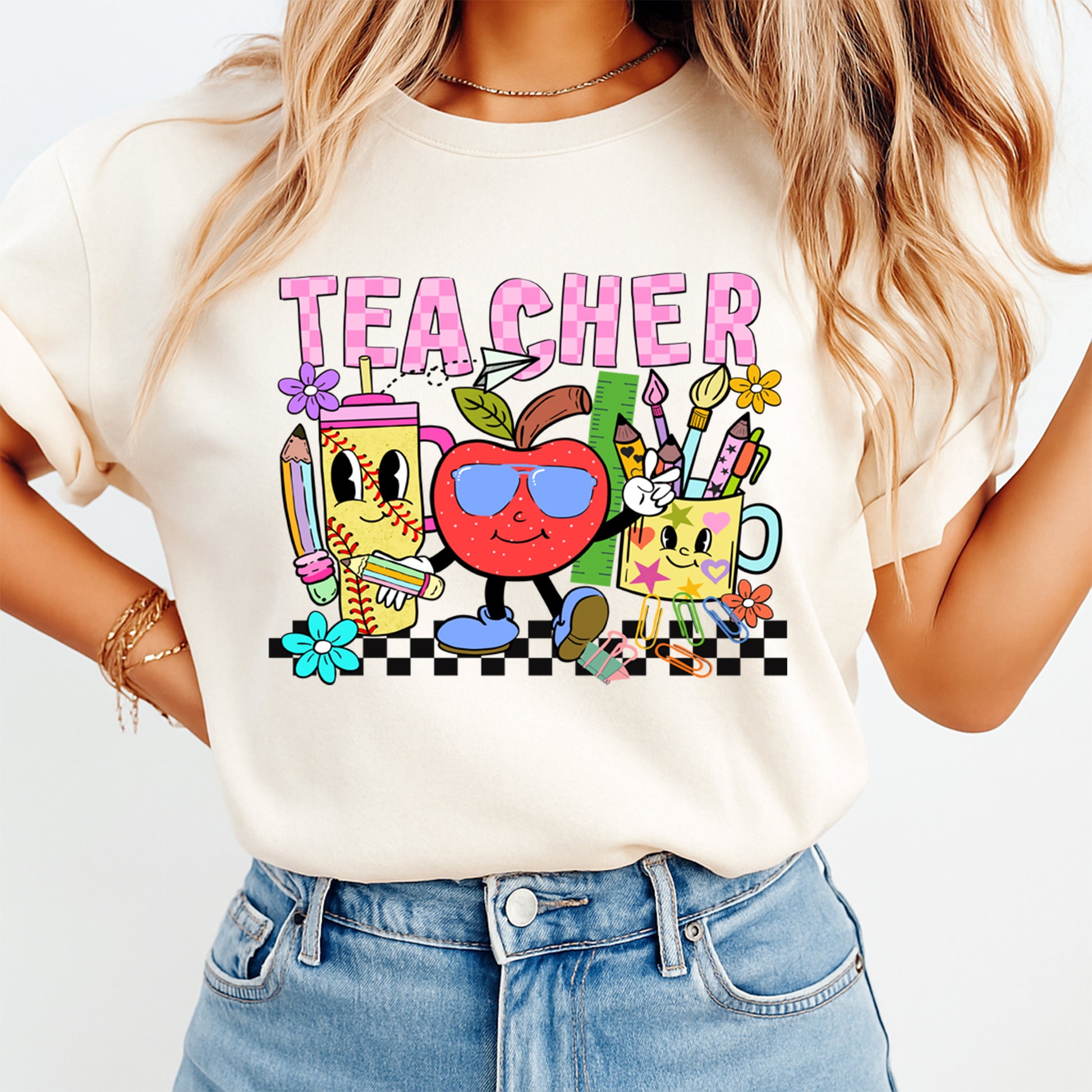 Person wearing a white t-shirt with a colorful 'TEACHER' graphic design.