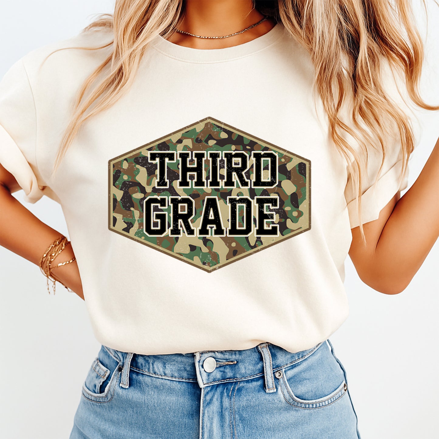 Person wearing a white t-shirt with 'THIRD GRADE' in a camouflage hexagon design.