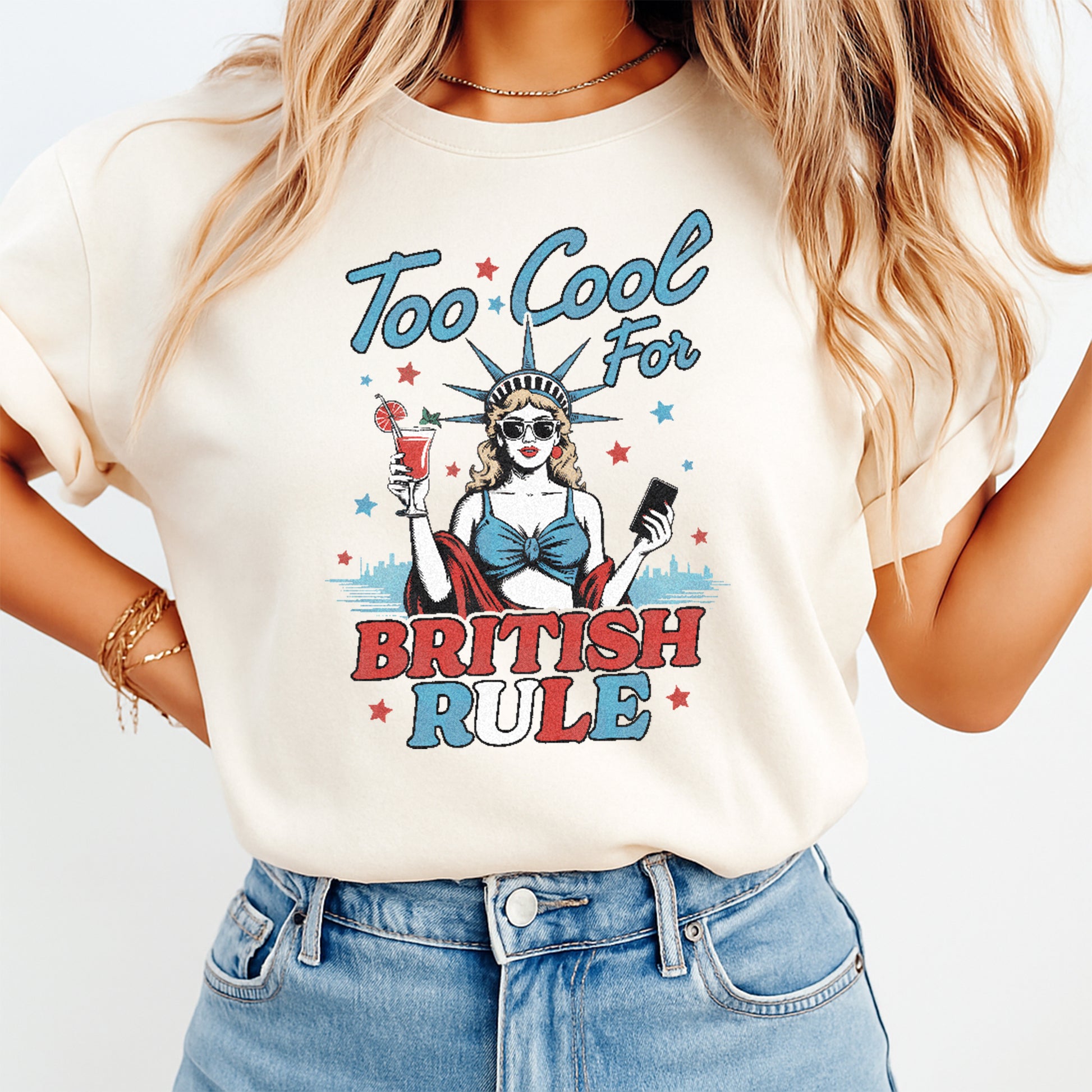 Person wearing a t-shirt with a graphic design and text 'Too Cool for British Rule' on a plain background