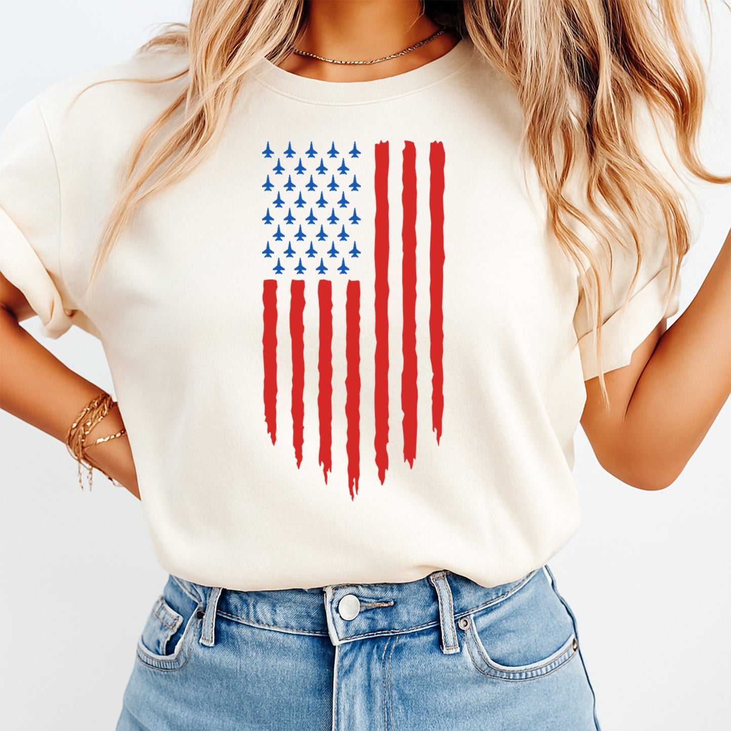 Person wearing a white t-shirt with an American flag design on a plain background