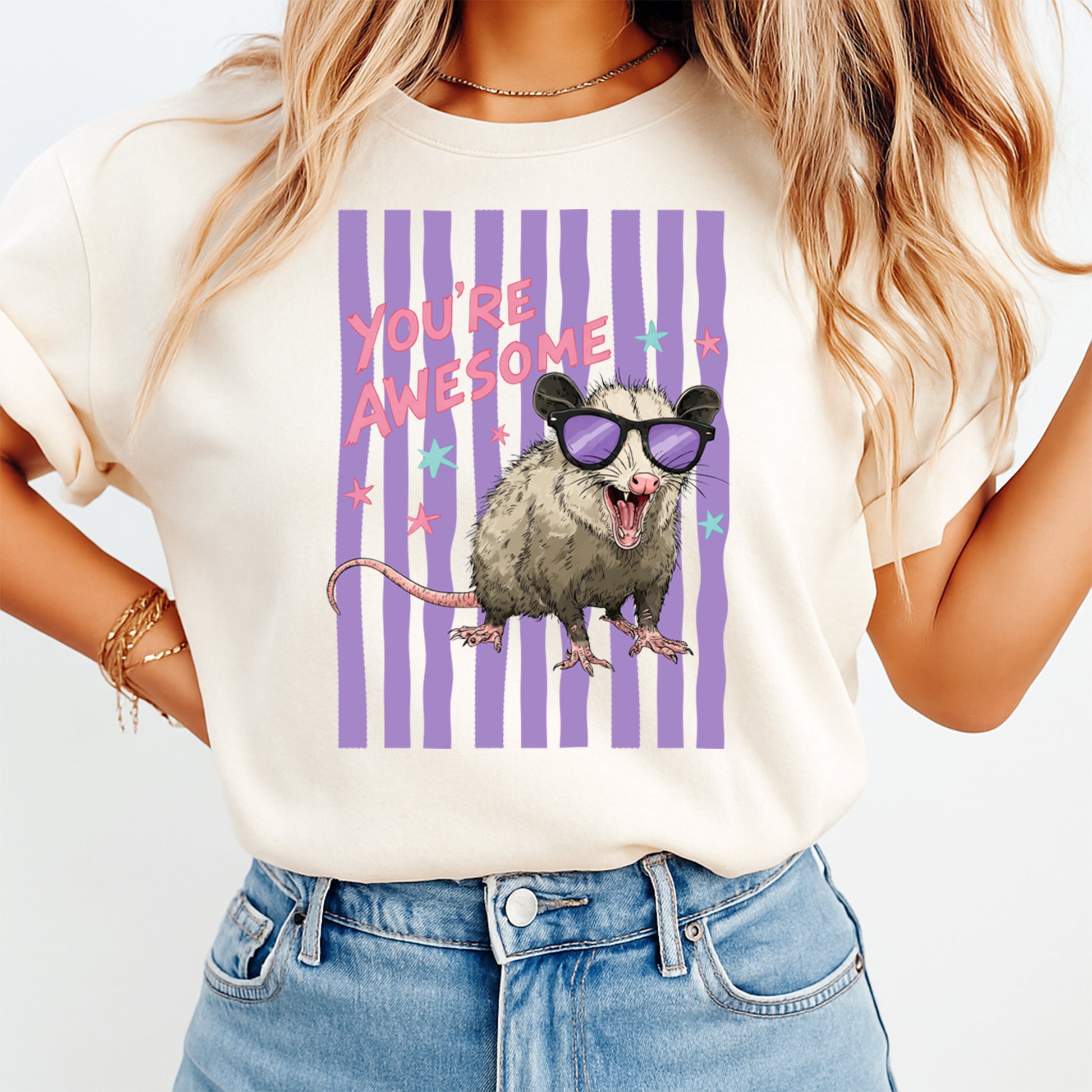 Person wearing a t-shirt with an opossum graphic and 'You're Awesome' text on a white background