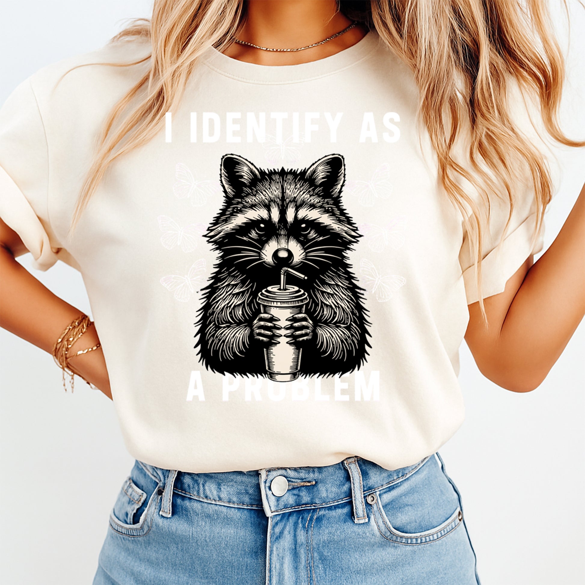 Person wearing a t-shirt with a raccoon graphic and text on a plain background