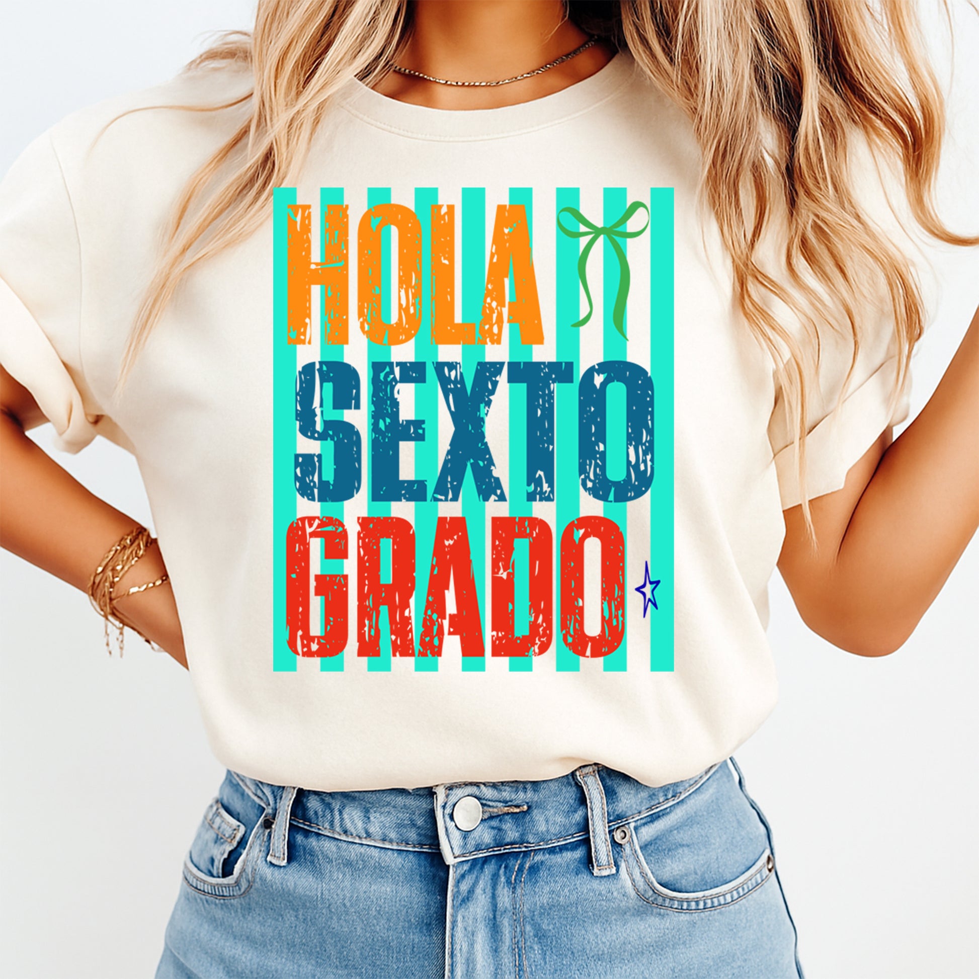 Person wearing a t-shirt with colorful text 'Hola Sexto Grado' on a plain background