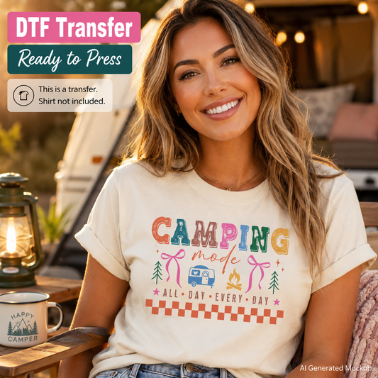 Woman wearing a t-shirt with 'Camping Mode' design, sitting outdoors with a campfire and lantern.