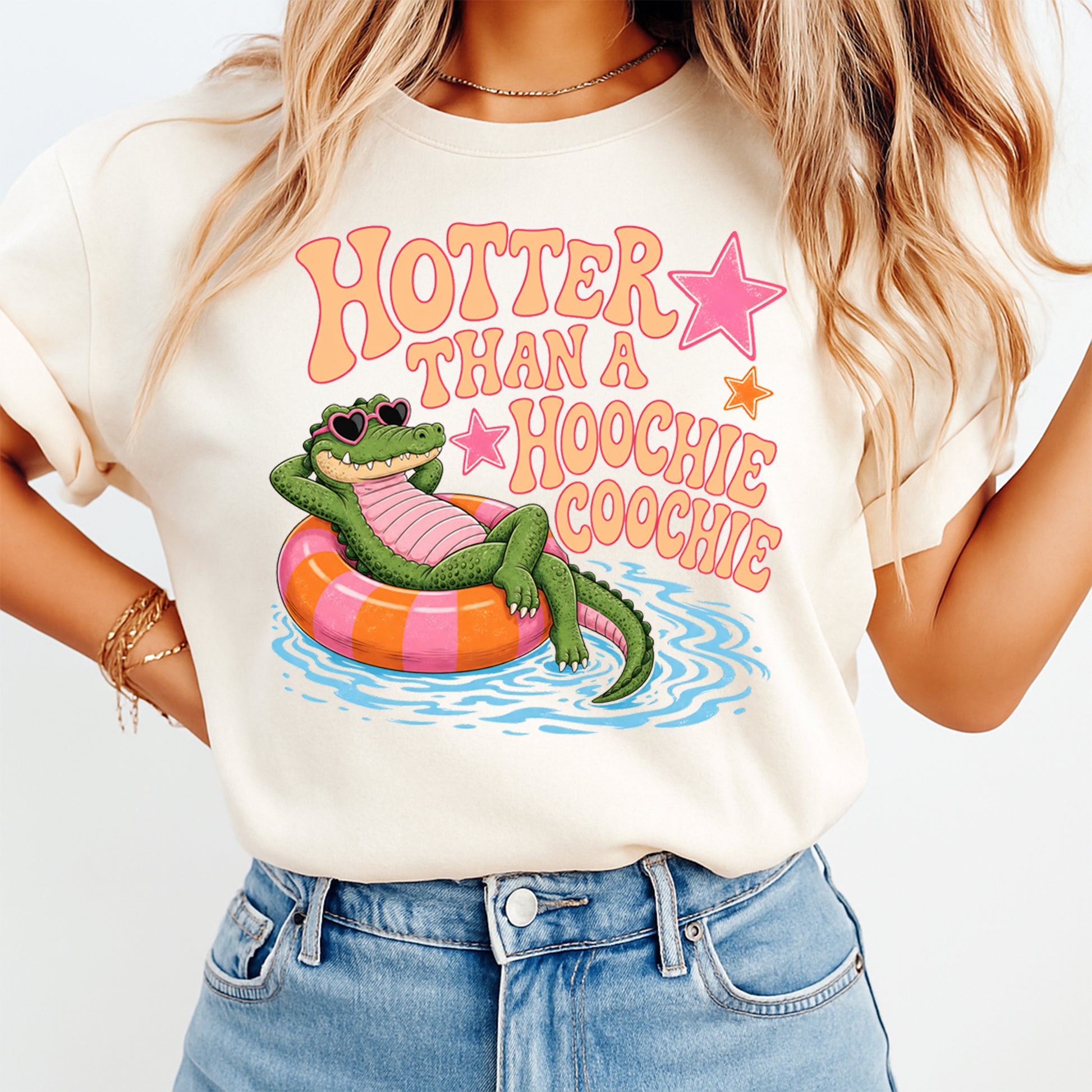Person wearing a t-shirt with a graphic of a crocodile in an inner tube and text 'Hotter Than a Hoochie Coochie'.