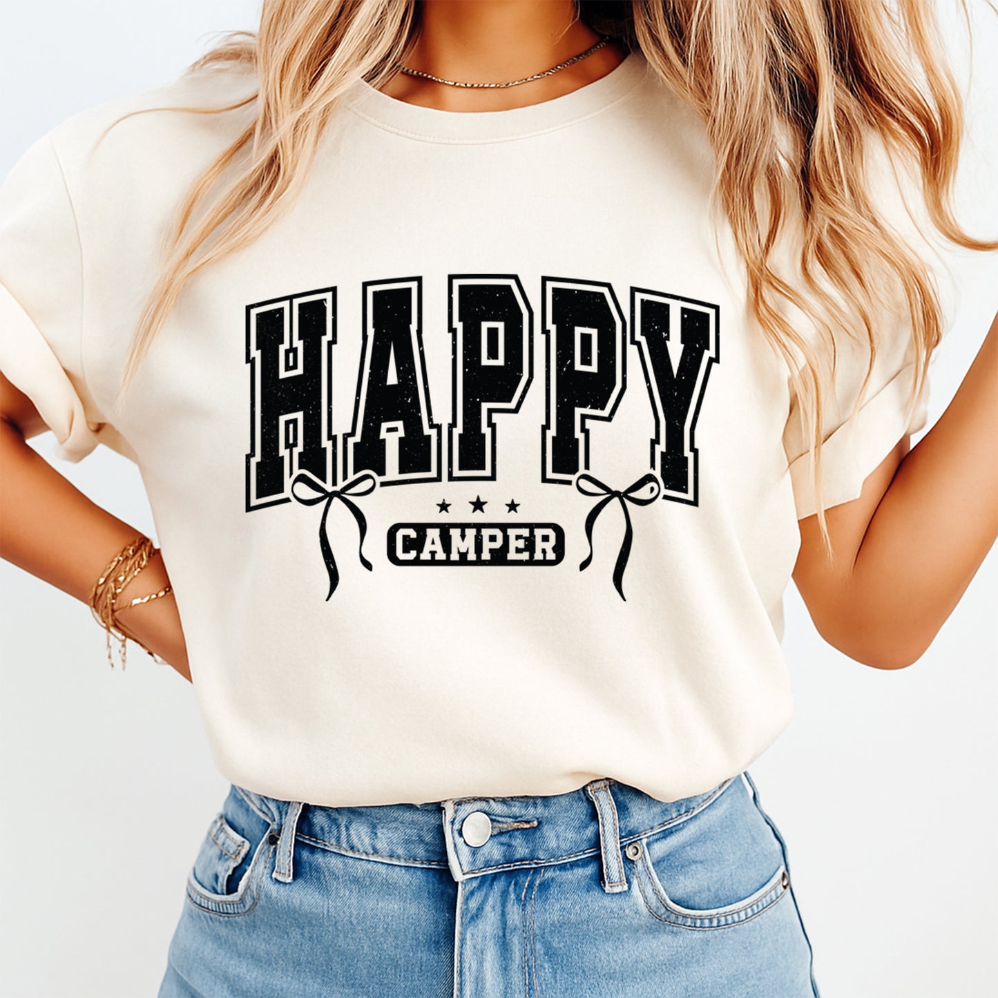 Person wearing a white t-shirt with 'HAPPY CAMPER' text design.