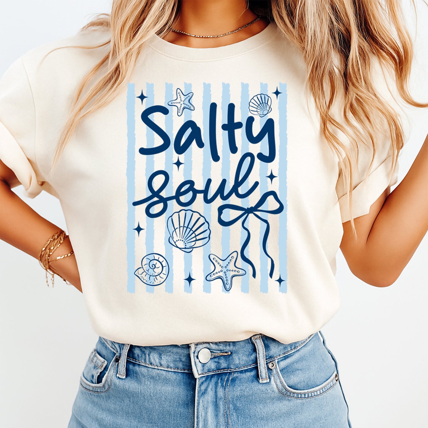 Person wearing a white t-shirt with 'Salty Soul' design on a plain background