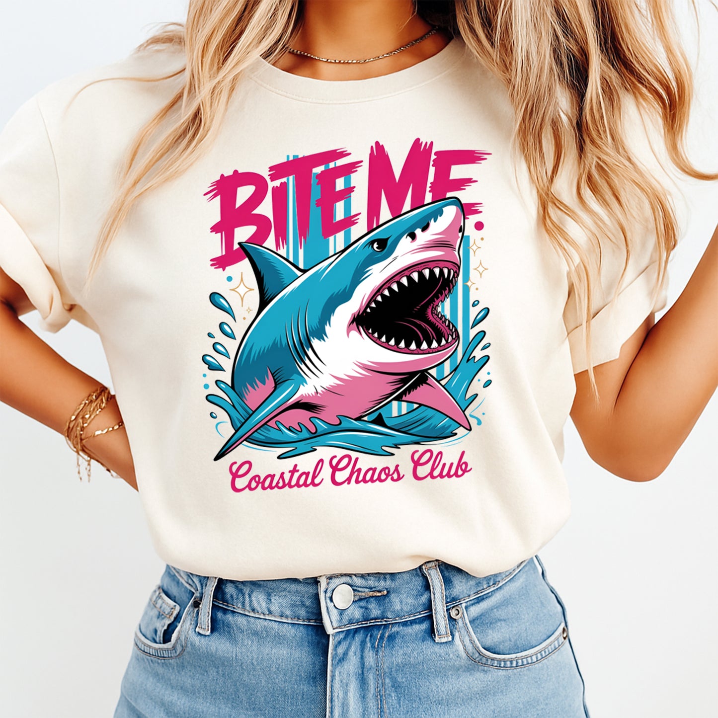 Person wearing a t-shirt with a shark graphic and text 'Bite Me Coastal Chaos Club' on a plain background