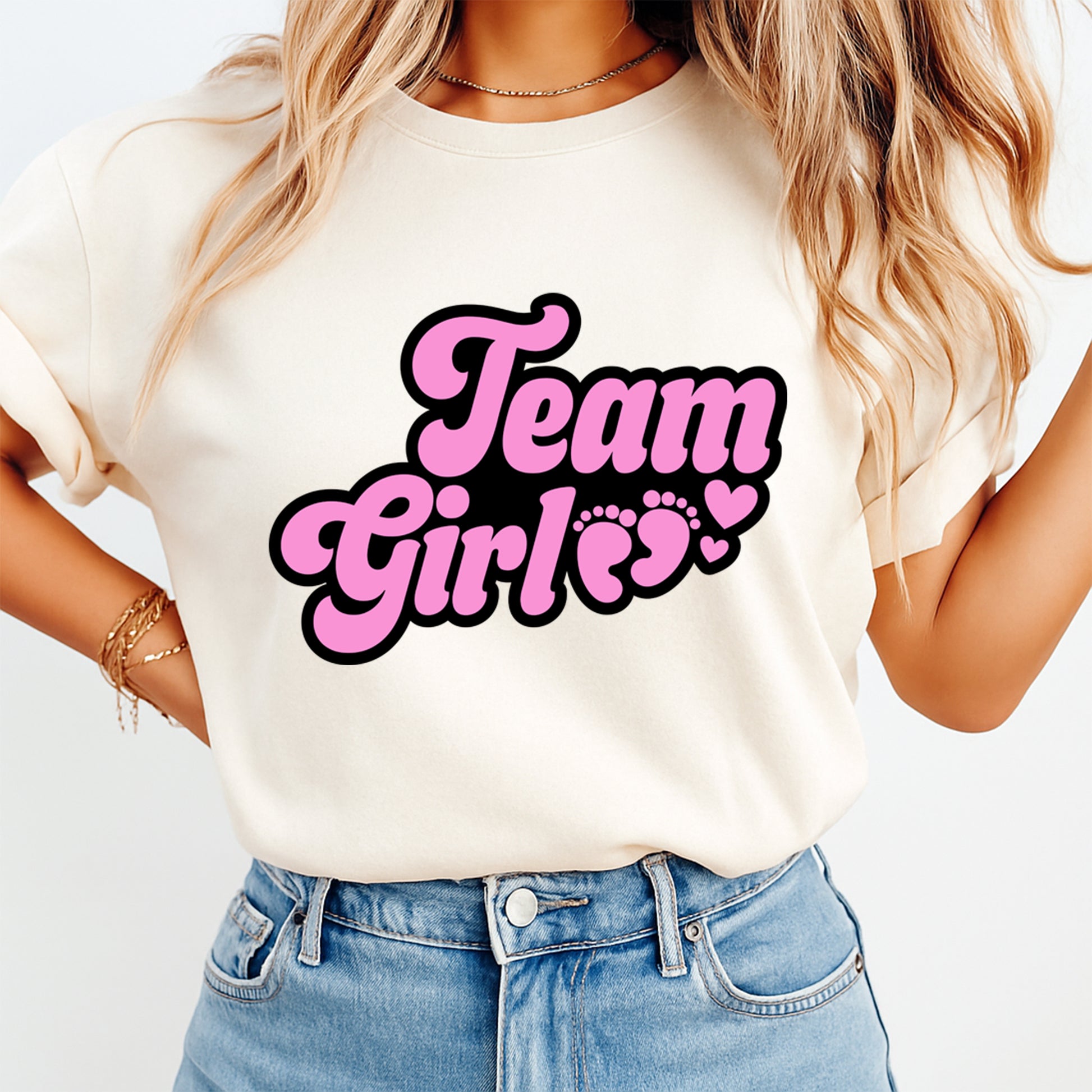 Person wearing a white t-shirt with 'Team Girls' text in pink and black on a plain background