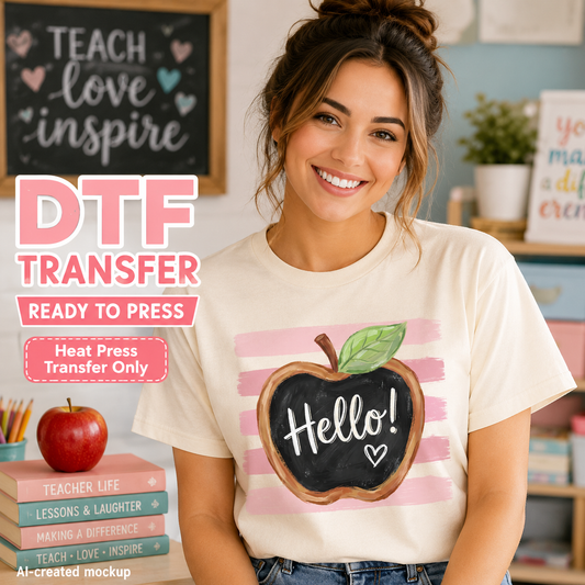A smiling woman wearing a cream T-shirt with a pink and black chalkboard apple graphic and the word 'Hello!' on the front, posed in a classroom-like setting with text overlays reading 'DTF TRANSFER READY TO PRESS'.