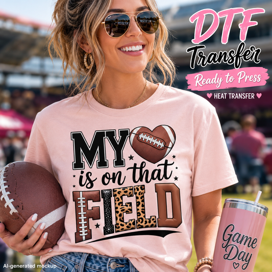 Woman wearing a pink shirt with the My Heart Is on That Field football DTF transfer while holding a football.