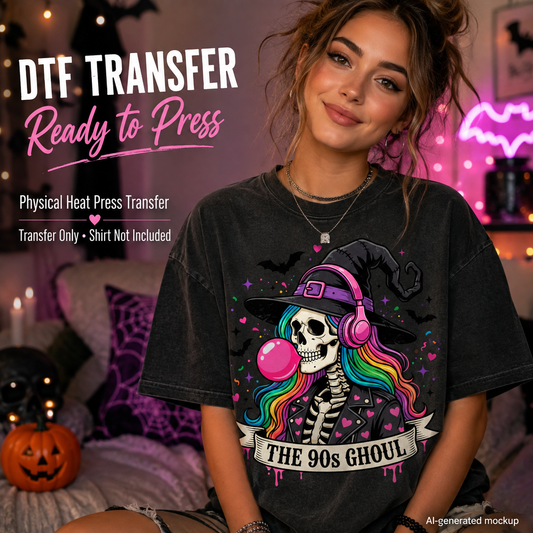 A woman wearing a black graphic t-shirt with a Halloween-themed design of a skeleton witch with rainbow hair and a pink bubblegum bubble. The background is a cozy, dimly lit bedroom with pink ambient lighting, a pumpkin, and spider decorations.