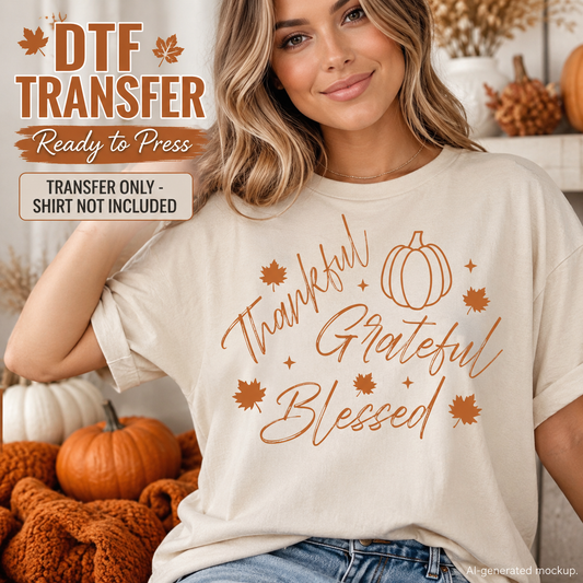 A woman wearing a cream-colored t-shirt with a copper-orange 'Thankful Grateful Blessed' autumn-themed transfer design, set against a cozy fall background with pumpkins and a blanket. Text overlays indicate 'DTF TRANSFER Ready to Press'.