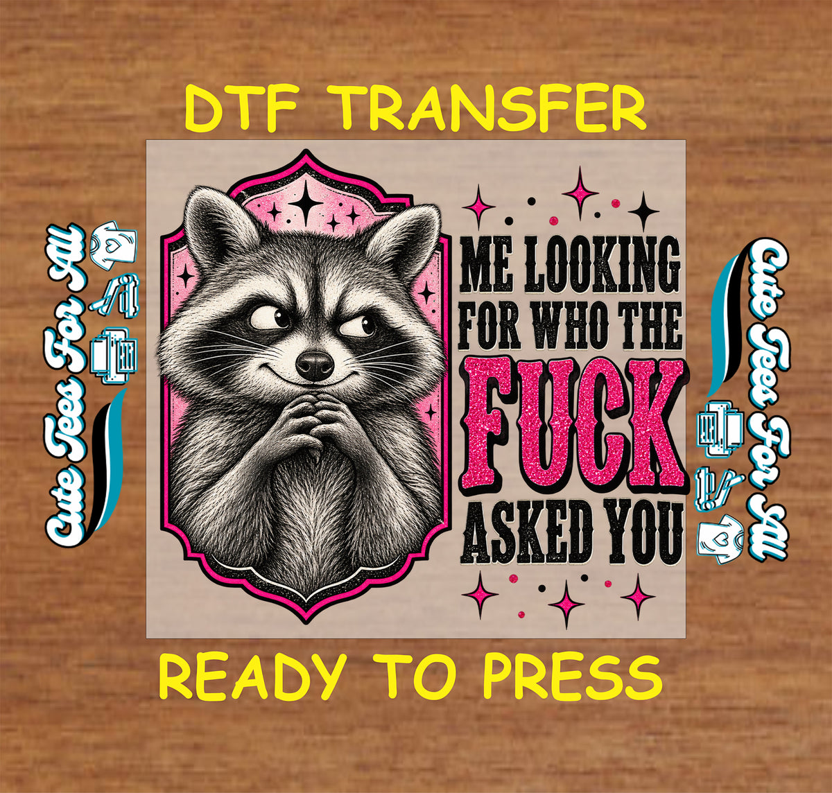 A DTF transfer design featuring a raccoon illustration and bold text reading 'ME LOOKING FOR WHO THE FUCK ASKED YOU' on a tan square, centered on a wood background with yellow text reading 'DTF TRANSFER' and 'READY TO PRESS'.