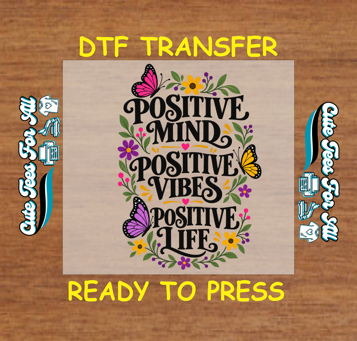 A DTF transfer design preview on a wood-textured background. The central square shows the phrase “POSITIVE MIND POSITIVE VIBES POSITIVE LIFE” in black script, surrounded by colorful flowers, leaves, and two butterflies.