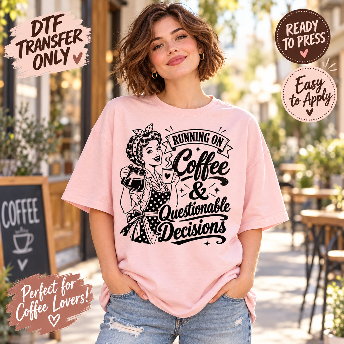 A woman wearing a light pink graphic t-shirt with a black retro-style illustration and the text 'Running on Coffee & Questionable Decisions'. The background is a blurred outdoor cafe setting.