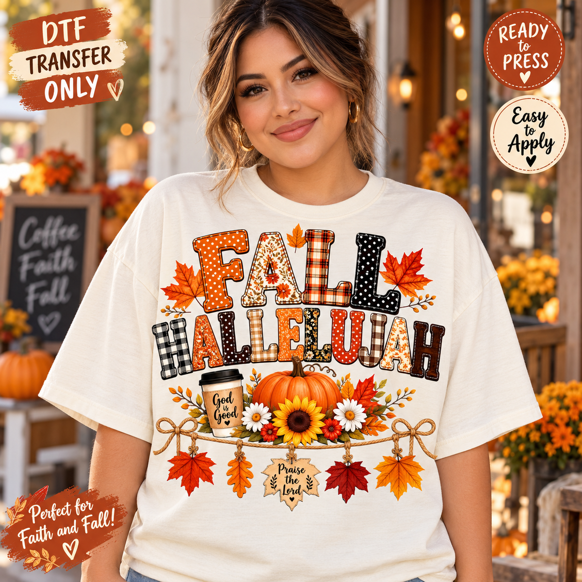 A woman wearing a white graphic T-shirt with a colorful autumn-themed 'FALL HALLELUAH' design featuring pumpkins, sunflowers, and fall leaves. The background is a softly blurred fall-themed storefront with warm lights and pumpkins.