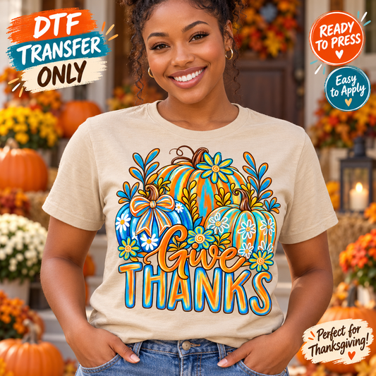 Woman modeling a cream shirt with Give Thanks lettering and orange and turquoise floral pumpkins accented by a bow; Thanksgiving DTF transfer mockup.