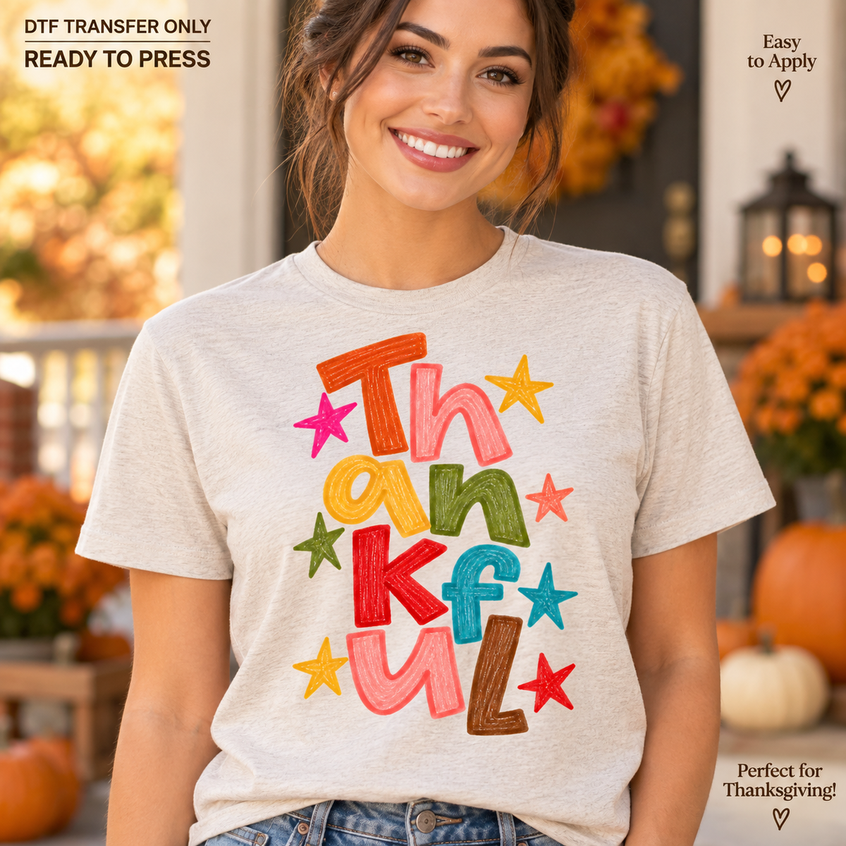 Woman in a light heather grey shirt displaying stacked multicolor Thankful lettering with colorful stars.