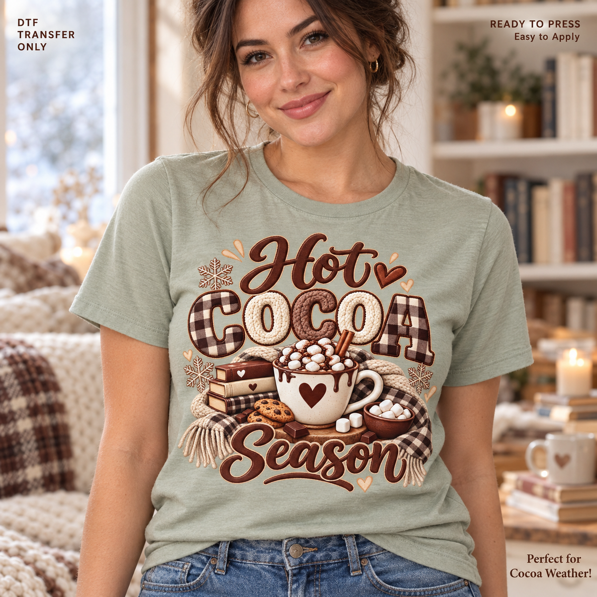 Lifestyle mockup of a woman wearing a sage green shirt showing Hot Cocoa Season lettering with a marshmallow heart mug, books, and flowing plaid bow. DTF transfer only; shirt not included.