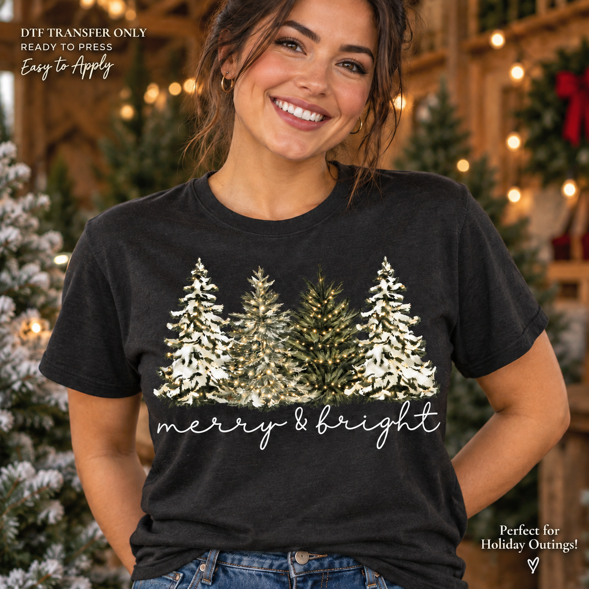 Lifestyle mockup of a woman wearing a black shirt showing Snow-covered evergreen trees above Merry and Bright script. DTF transfer only; shirt not included.