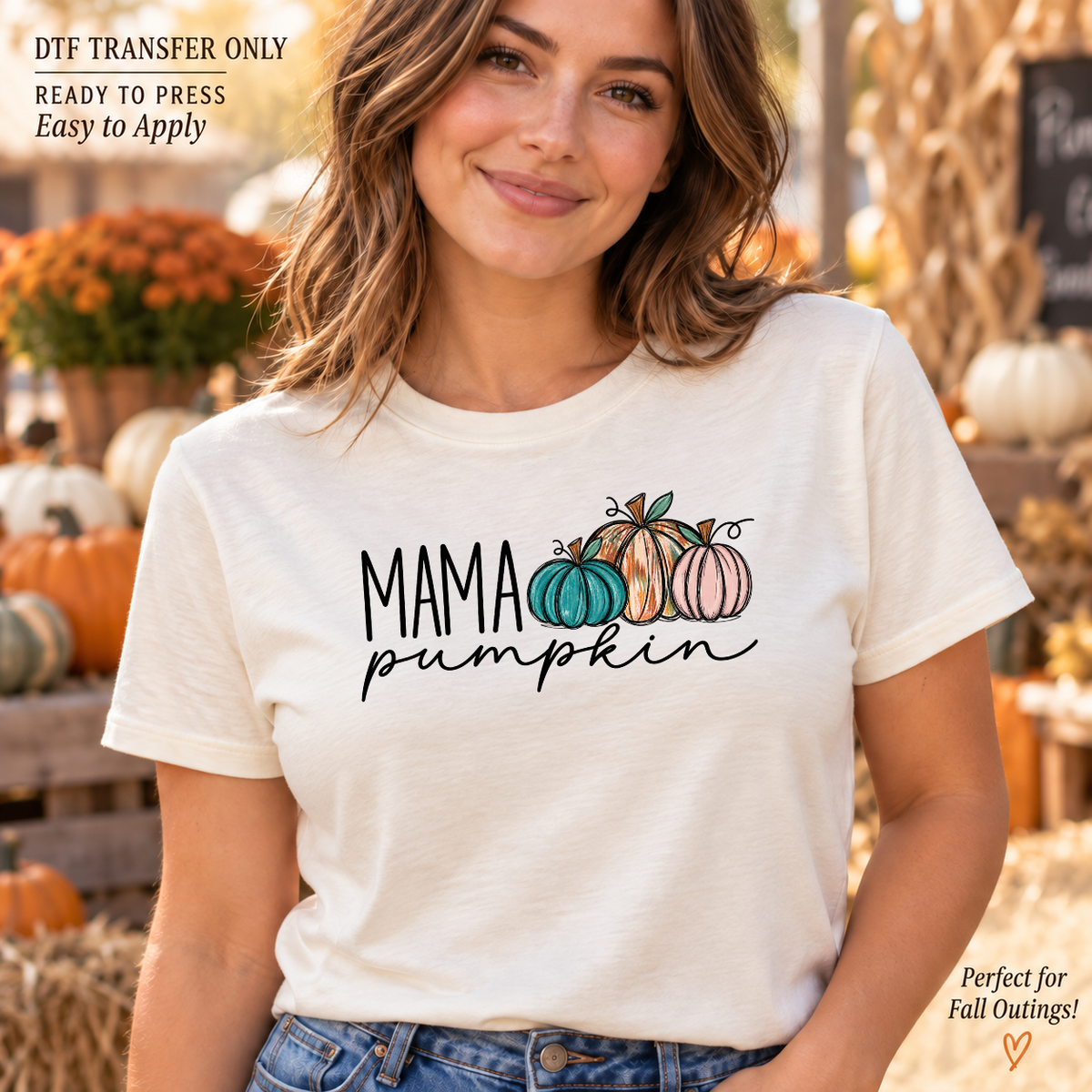 Lifestyle mockup of a woman wearing a cream shirt showing Mama Pumpkin lettering with teal, orange, and pink pumpkins. DTF transfer only; shirt not included.