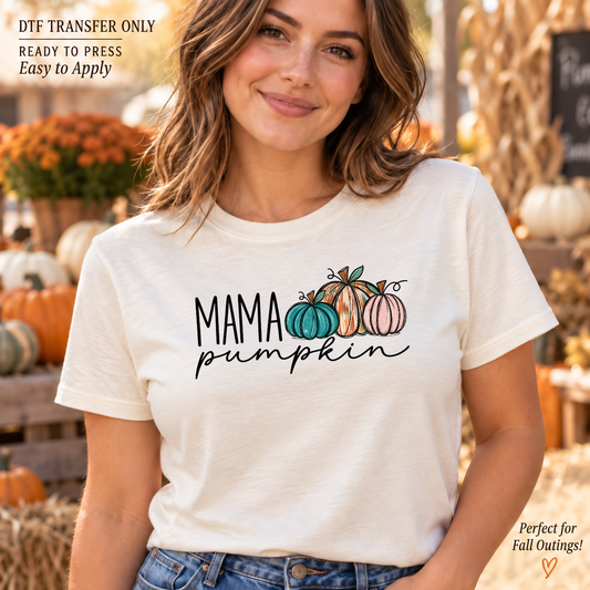 Lifestyle mockup of a woman wearing a cream shirt showing Mama Pumpkin lettering with teal, orange, and pink pumpkins. DTF transfer only; shirt not included.