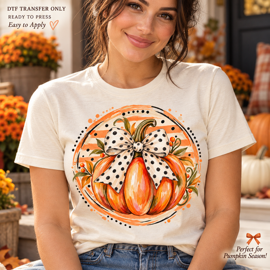 Lifestyle mockup of a woman wearing a cream shirt showing Watercolor orange pumpkin with polka dot bow inside a round orange decorative backdrop. DTF transfer only; shirt not included.