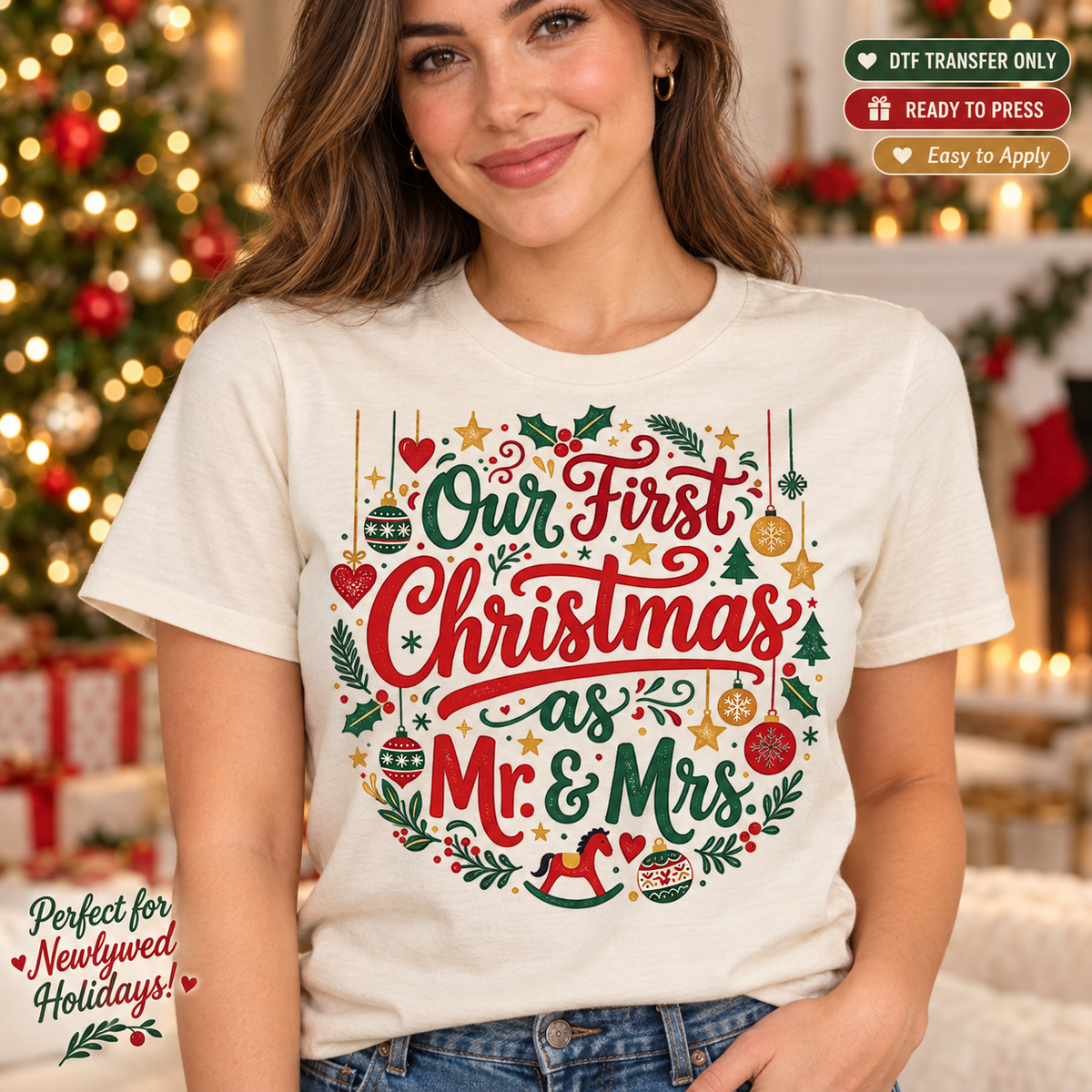 Lifestyle mockup of a woman wearing a cream shirt showing Our First Christmas as Mr and Mrs lettering with ornaments, hearts, holly, and stars. DTF transfer only; shirt not included.