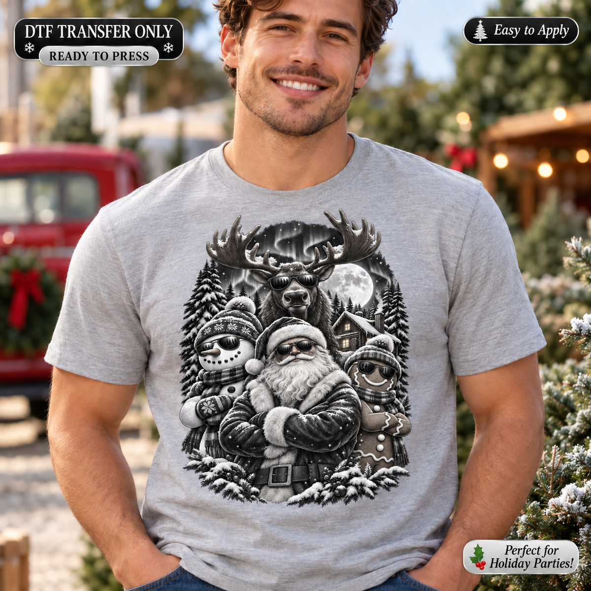 Lifestyle mockup of a man wearing a heather grey shirt showing Black-and-white Santa and snowmen with a large antlered reindeer, snowy trees, cabin, and moon. DTF transfer only; shirt not included.