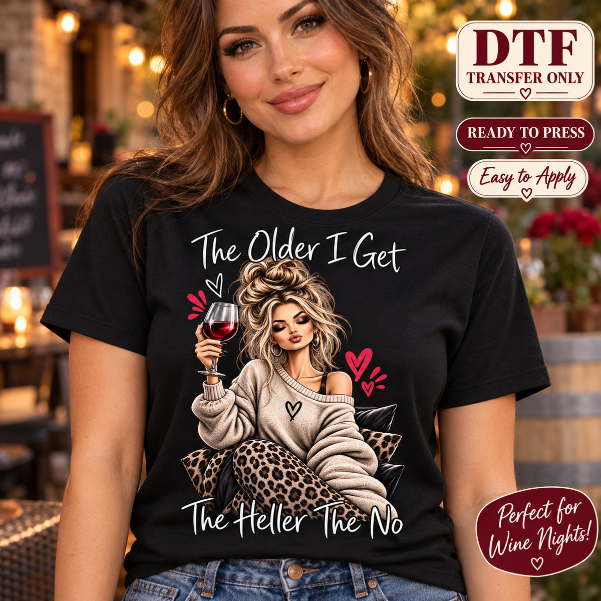 Lifestyle mockup of a woman wearing a black shirt showing Woman holding a red wine glass in leopard-print pants with The Older I Get The Heller The No lettering. DTF transfer only; shirt not included.
