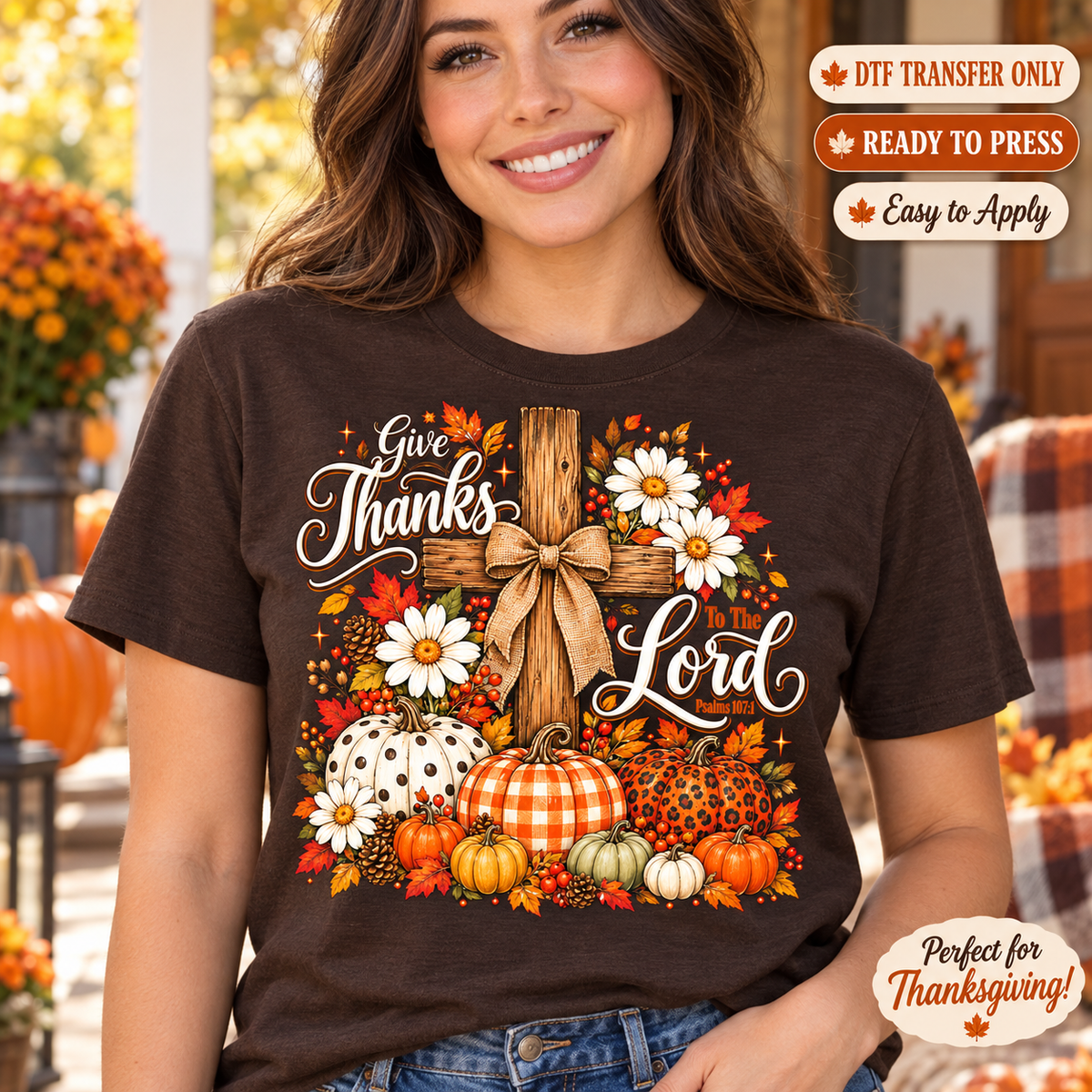 Lifestyle mockup of a woman wearing a brown shirt showing Give Thanks Lord wording with a wooden cross, bow, daisies, pumpkins, and autumn leaves. DTF transfer only; shirt not included.