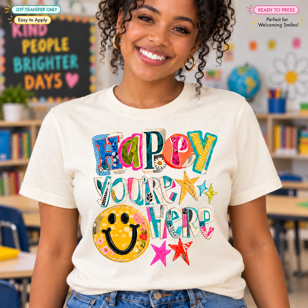 Lifestyle mockup of a woman wearing a cream shirt showing Happy You're Here in colorful patterned lettering with a yellow smiley face and stars. DTF transfer only; shirt not included.