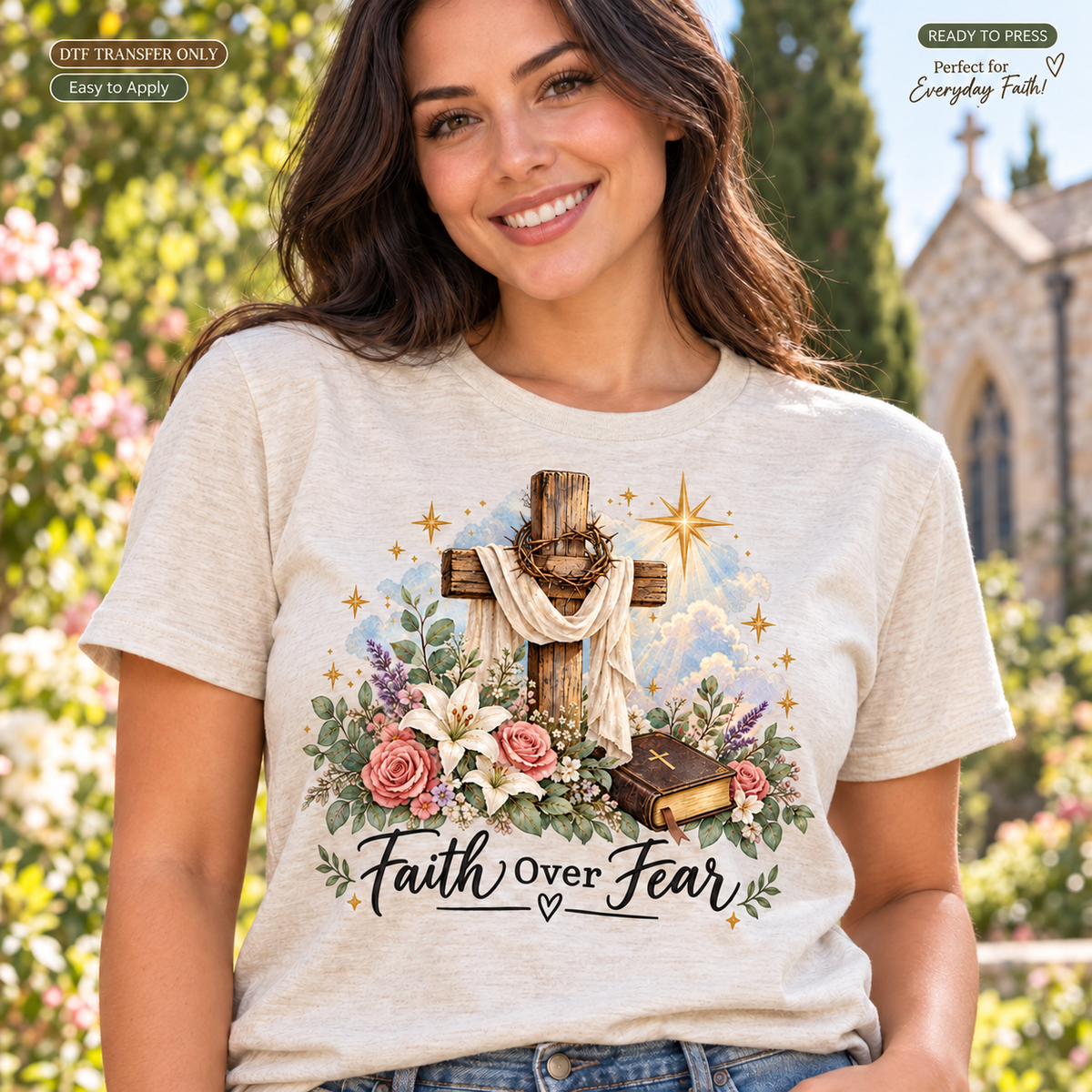 Lifestyle mockup of a woman wearing a heather grey shirt showing Faith Over Fear script with a draped wooden cross, pink and white flowers, and a book. DTF transfer only; shirt not included.