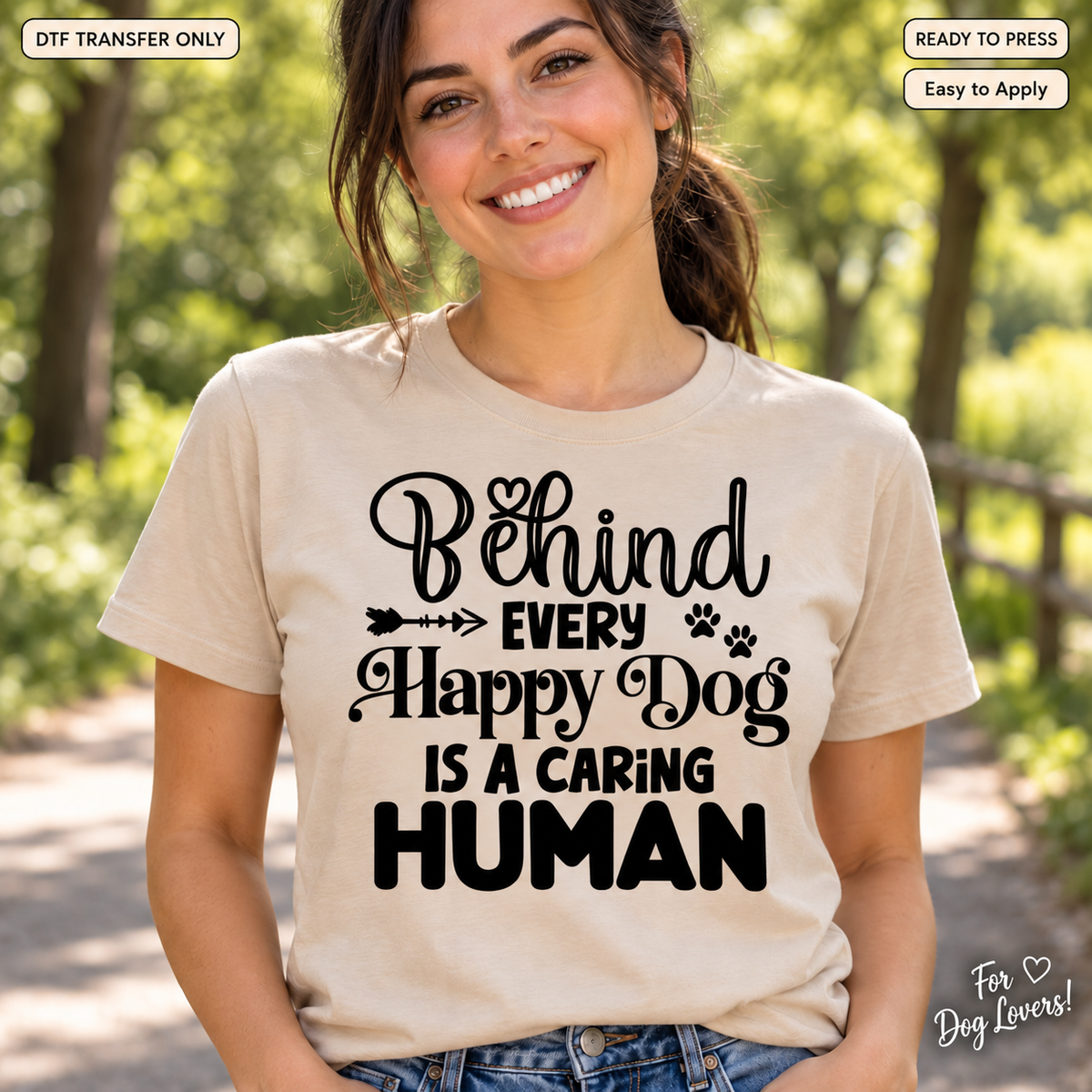 Woman in a cream shirt with black Behind Every Happy Dog Is a Caring Human lettering and small paw prints.