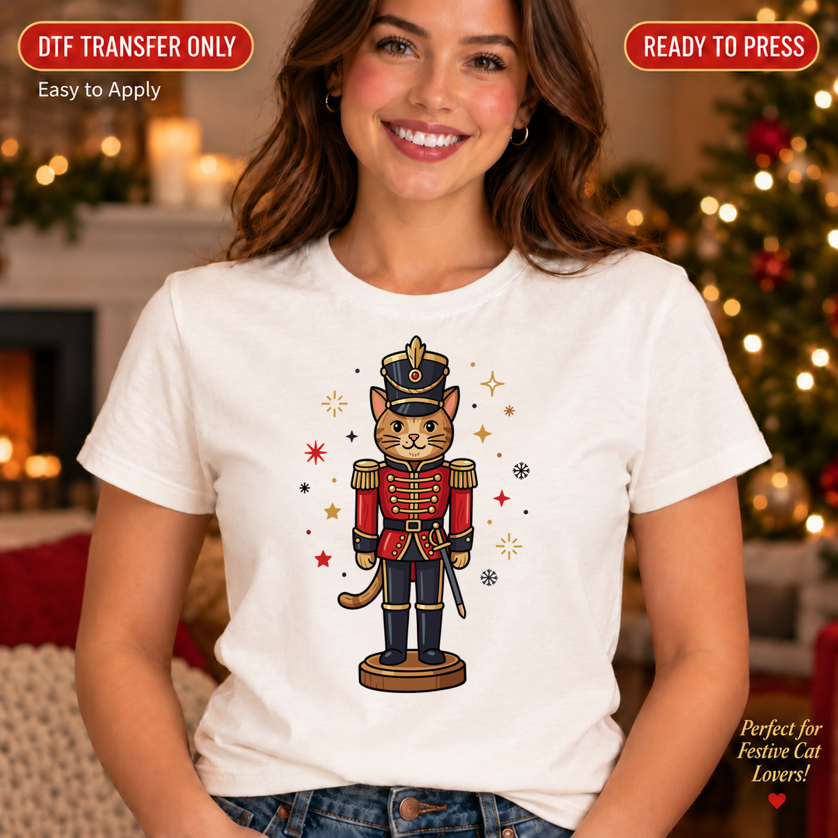 Woman wearing a white shirt with an illustrated cat dressed as a red and navy Christmas nutcracker soldier.