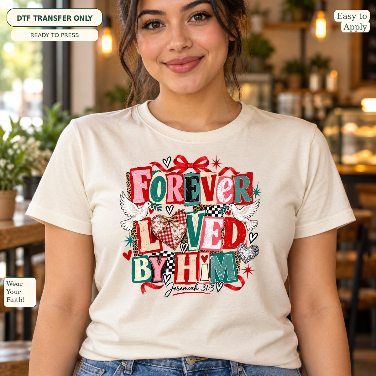 Woman wearing a cream tee with red and green Forever Loved by Him lettering, hearts and Jeremiah 31:3.