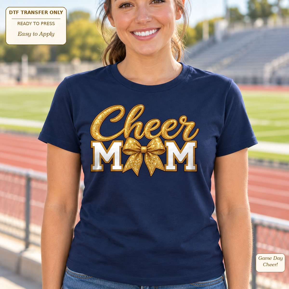 Woman wearing a navy tee with gold-look Cheer Mom lettering and a large gold glitter-effect bow.