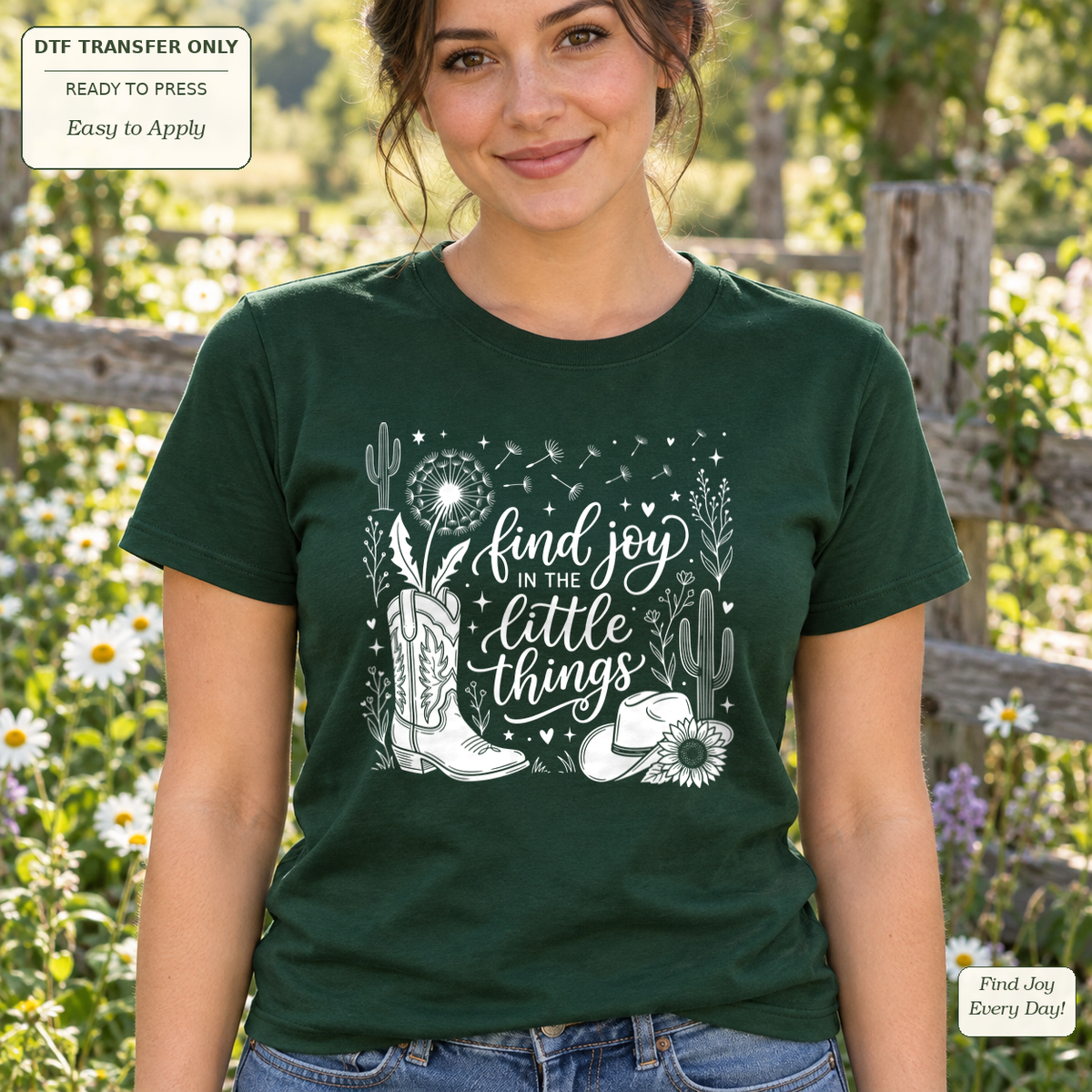 Woman in a dark green tee with white Find joy in the little things script, a cowboy boot, hat and flowers.