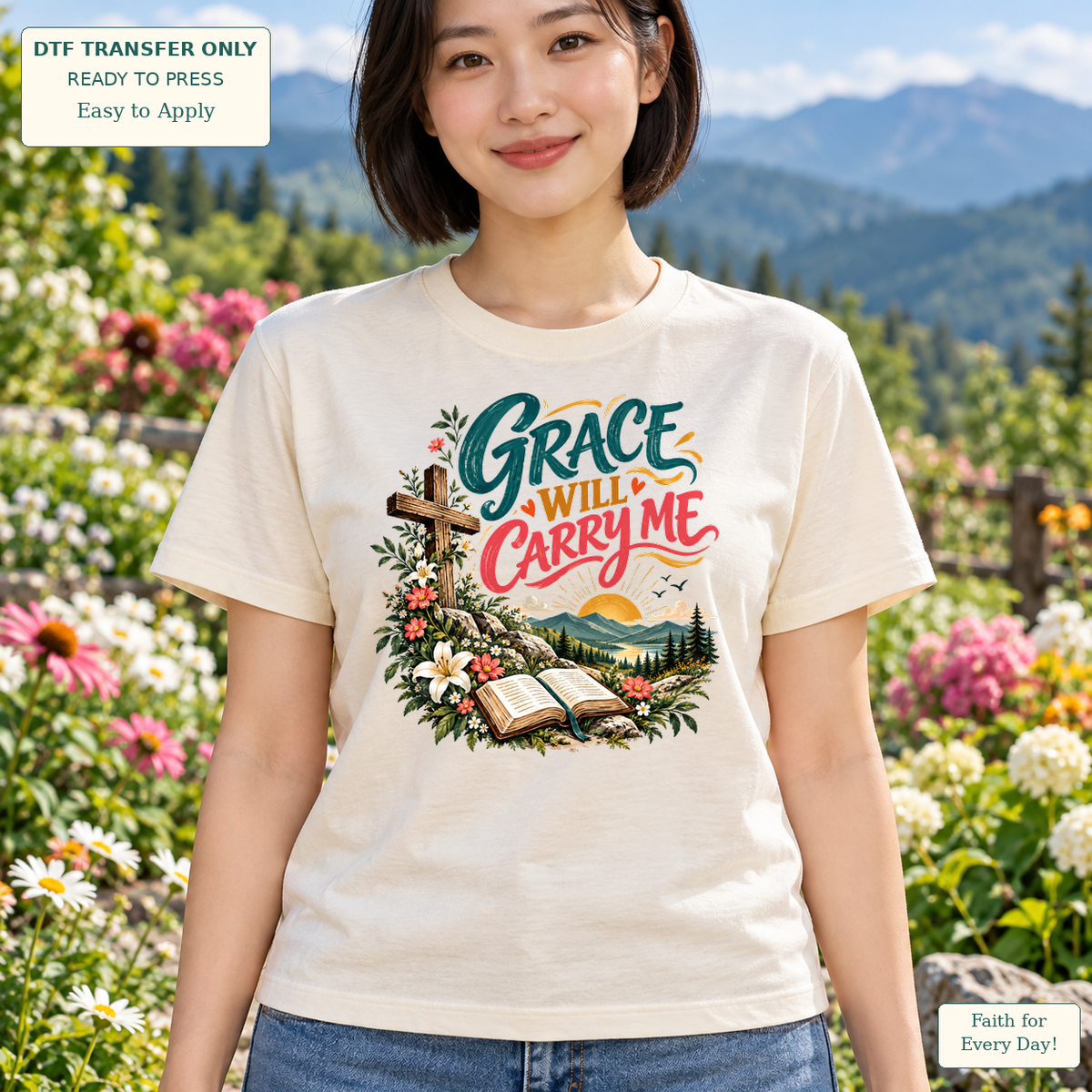 Woman wearing a cream tee with Grace Will Carry Me lettering, a cross, open Bible, flowers and a landscape.