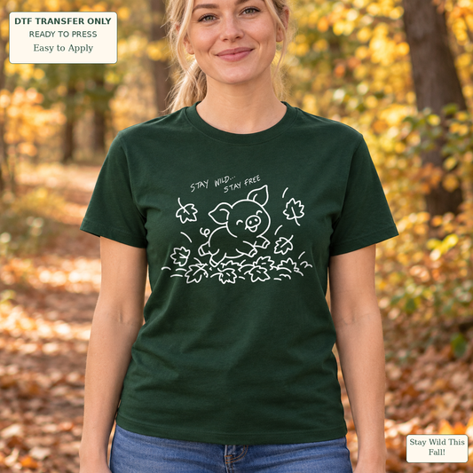 Woman wearing a dark green tee with white line art of a jumping pig, autumn leaves and Stay Wild Stay Free wording.