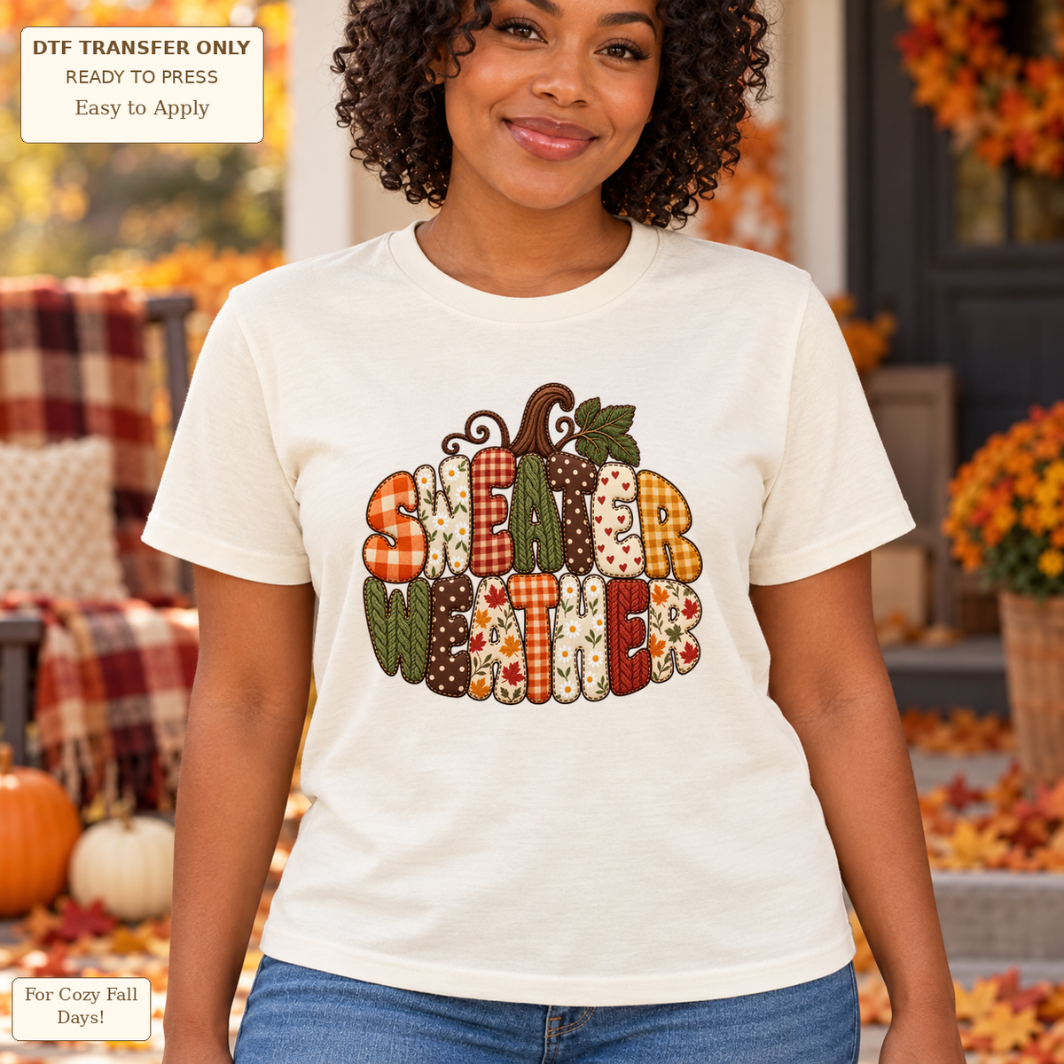 Woman in a cream tee with SWEATER WEATHER patchwork-style lettering arranged in a pumpkin shape with a stem and leaf.