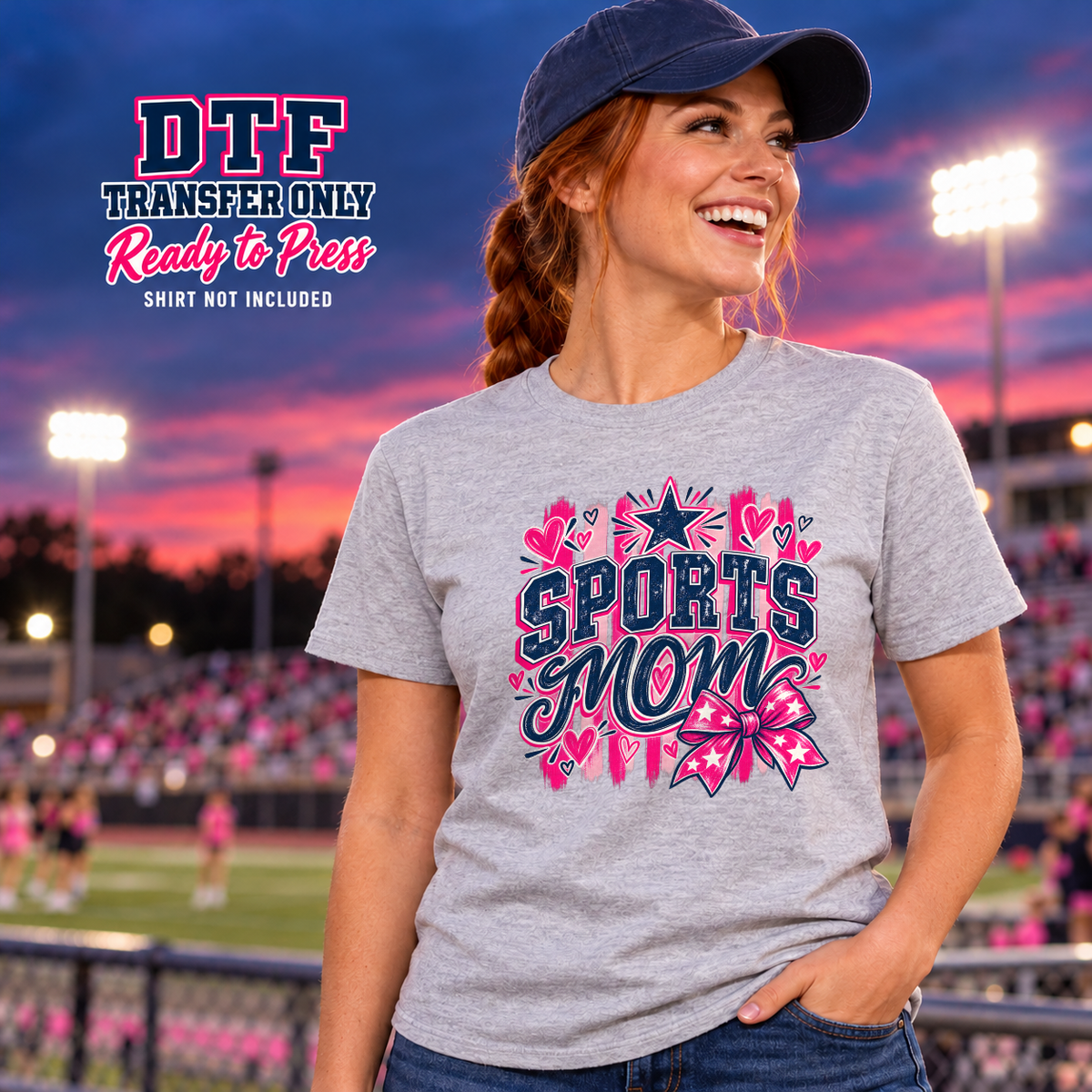 Woman wearing a gray tee with Sports Mom lettering, pink hearts, stars and a pink bow.