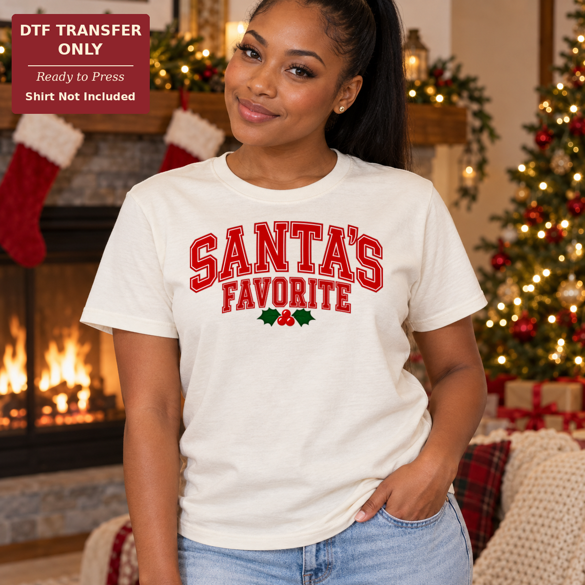 Woman wearing a cream tee with red varsity-style Santa’s Favorite lettering and a small holly accent.