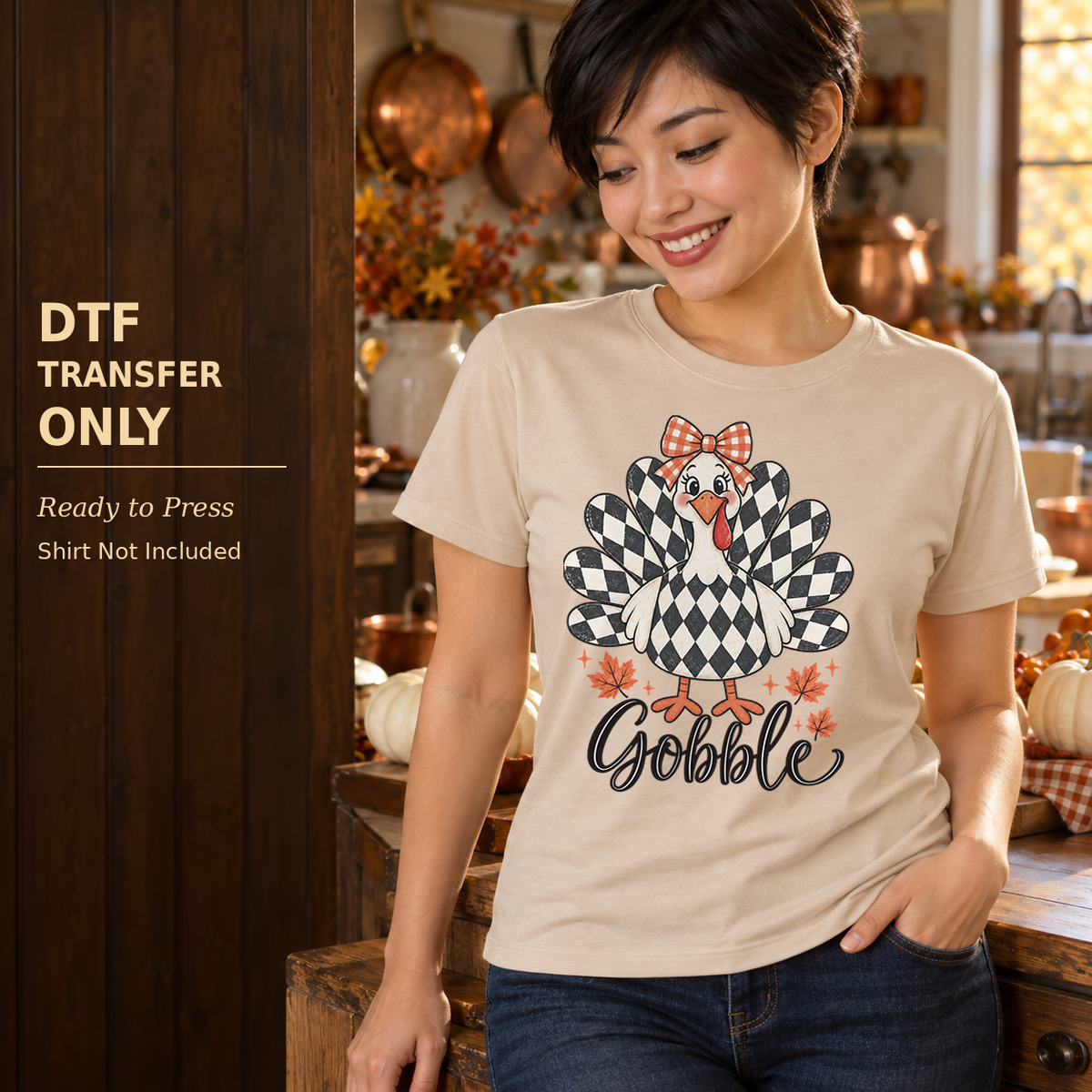 Woman in a cream shirt with a checkerboard-feather turkey, plaid bow, and Gobble script in a fall kitchen.