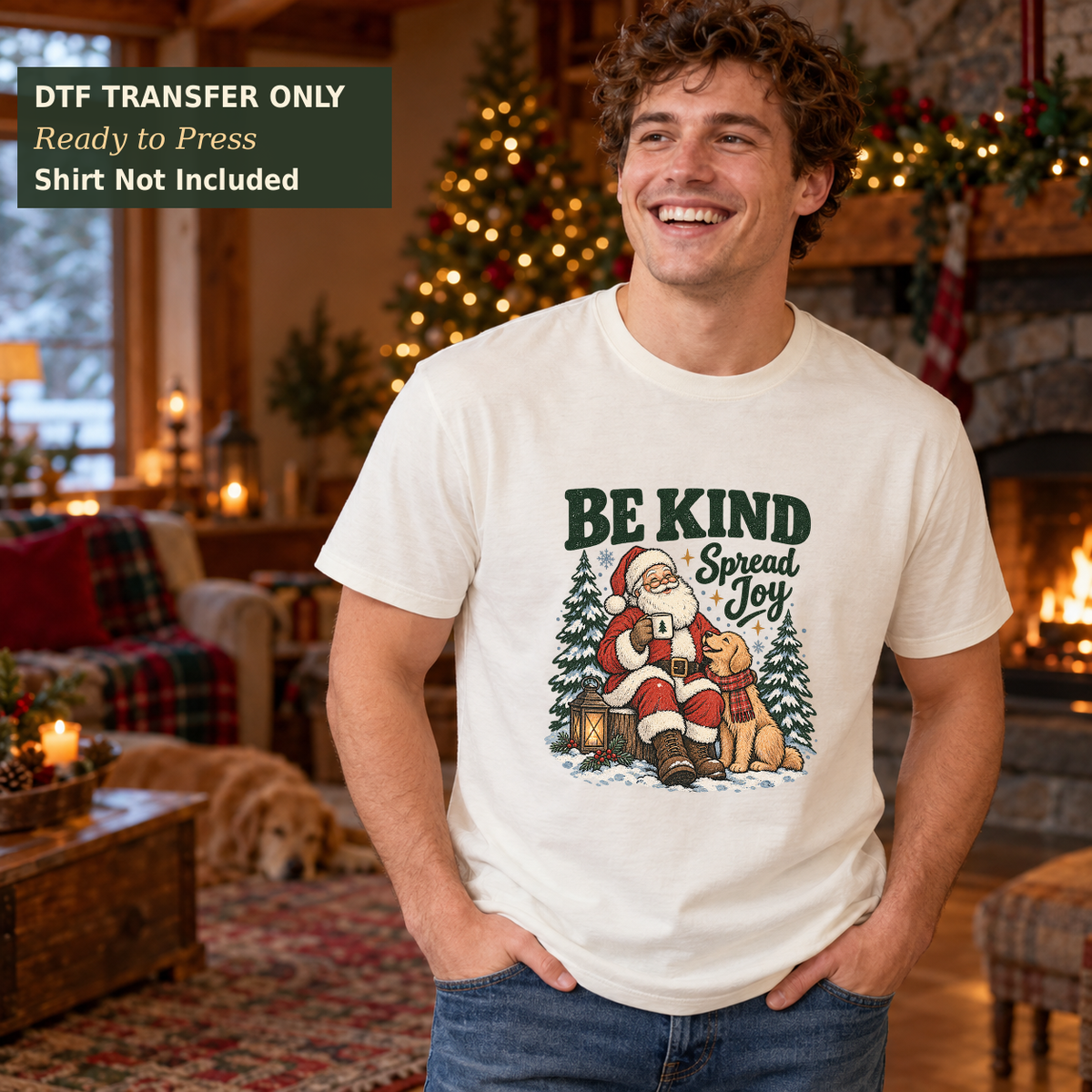 Man wearing a white Be Kind Spread Joy shirt with a seated Santa, small animals, and evergreen trees in a Christmas lodge.